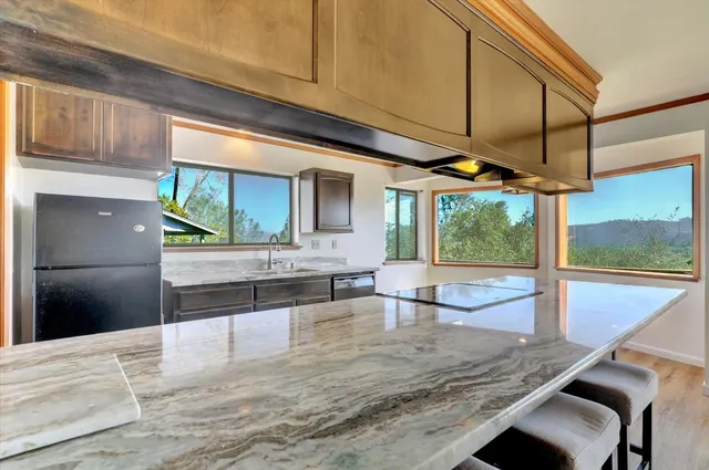 a view of a kitchen with kitchen island a sink and wooden floor