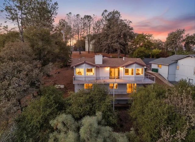 an aerial view of a house with a yard and trees