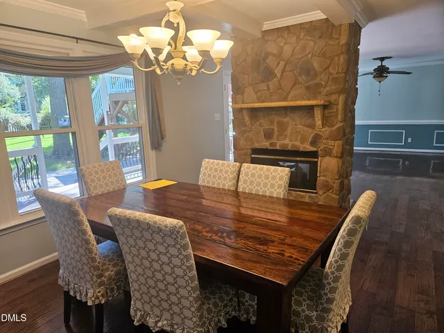 a view of a dining room with furniture a chandelier and large windows