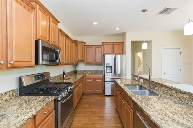 a kitchen with stainless steel appliances granite countertop a sink stove and refrigerator