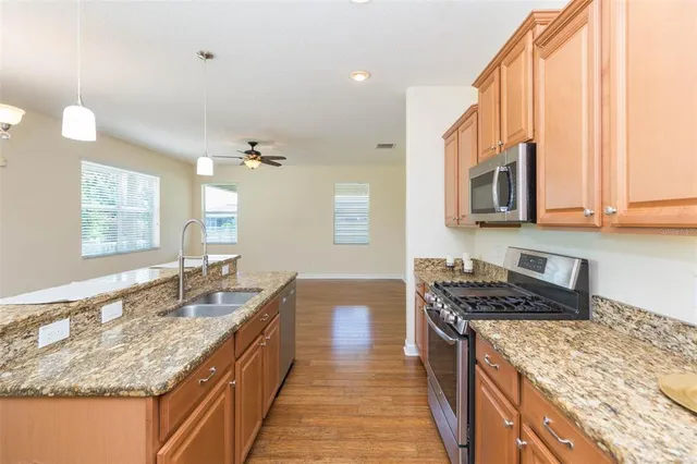 a kitchen with stainless steel appliances granite countertop a sink stove and cabinets
