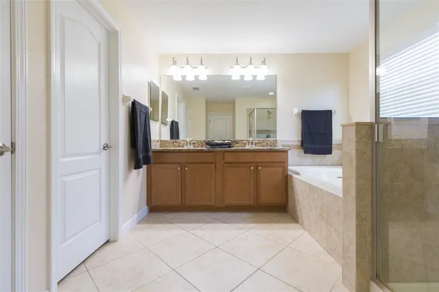 a large white kitchen with a sink and refrigerator