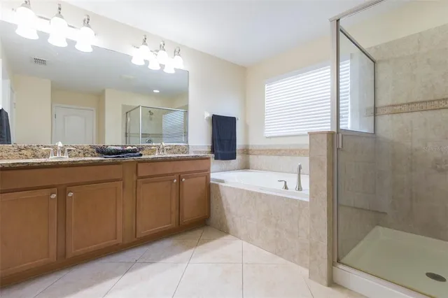 a spacious bathroom with a granite countertop sink a toilet mirror and bathtub