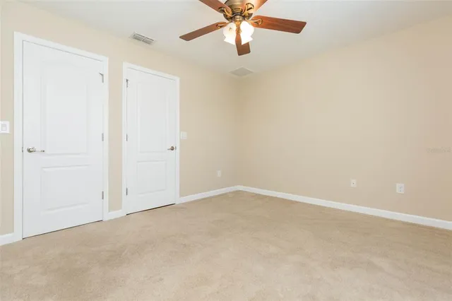 an empty room with chandelier fan