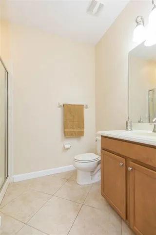 a bathroom with a toilet sink vanity and mirror