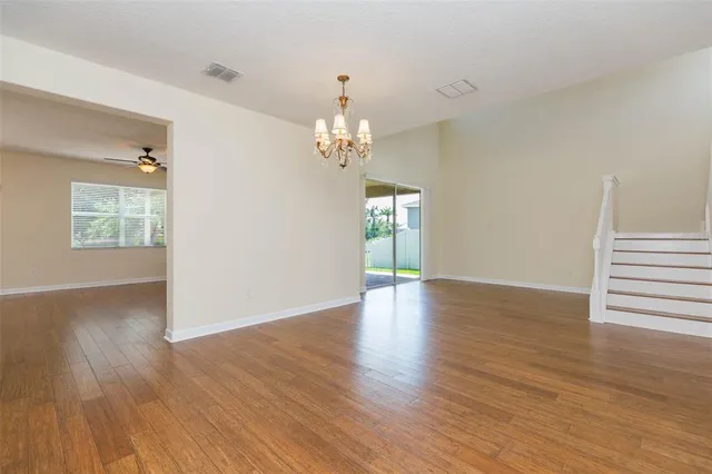 a view of a livingroom with wooden floor and a chandelier