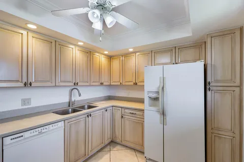 a kitchen with a refrigerator sink and cabinets