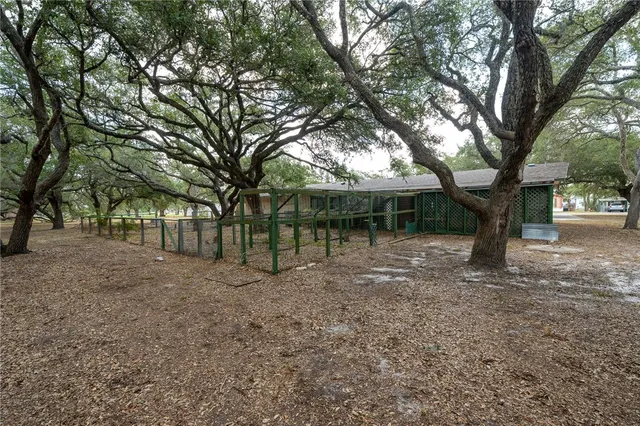 a front view of a house with a garden and tree
