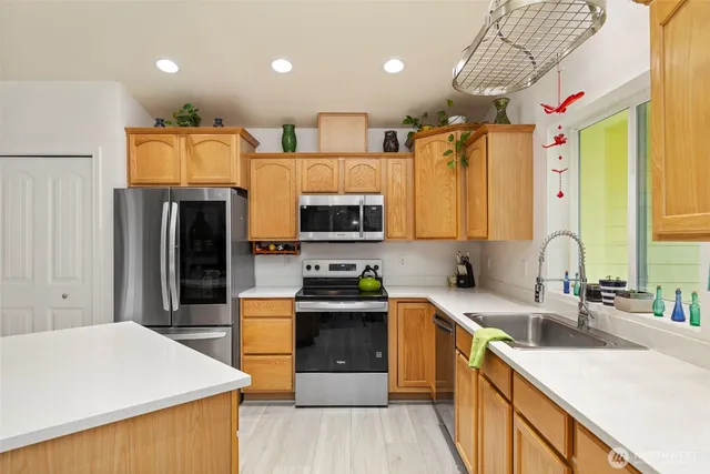a kitchen with stainless steel appliances granite countertop a sink stove and refrigerator