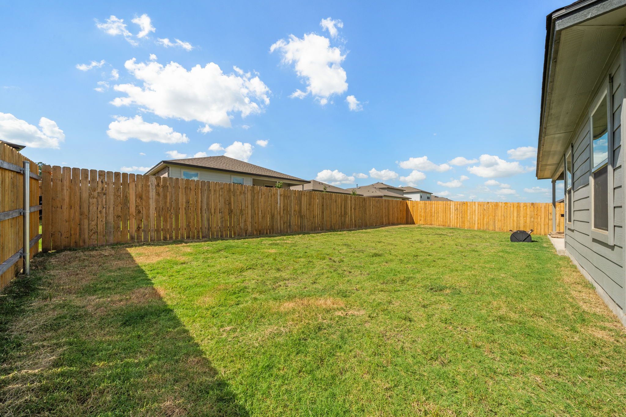 1117 Tipton Street Georgetown, TX 78633 - Photo 40 of 40 Expansive backyard featuring a lush lawn, privacy fencing, and a light gray siding exterior