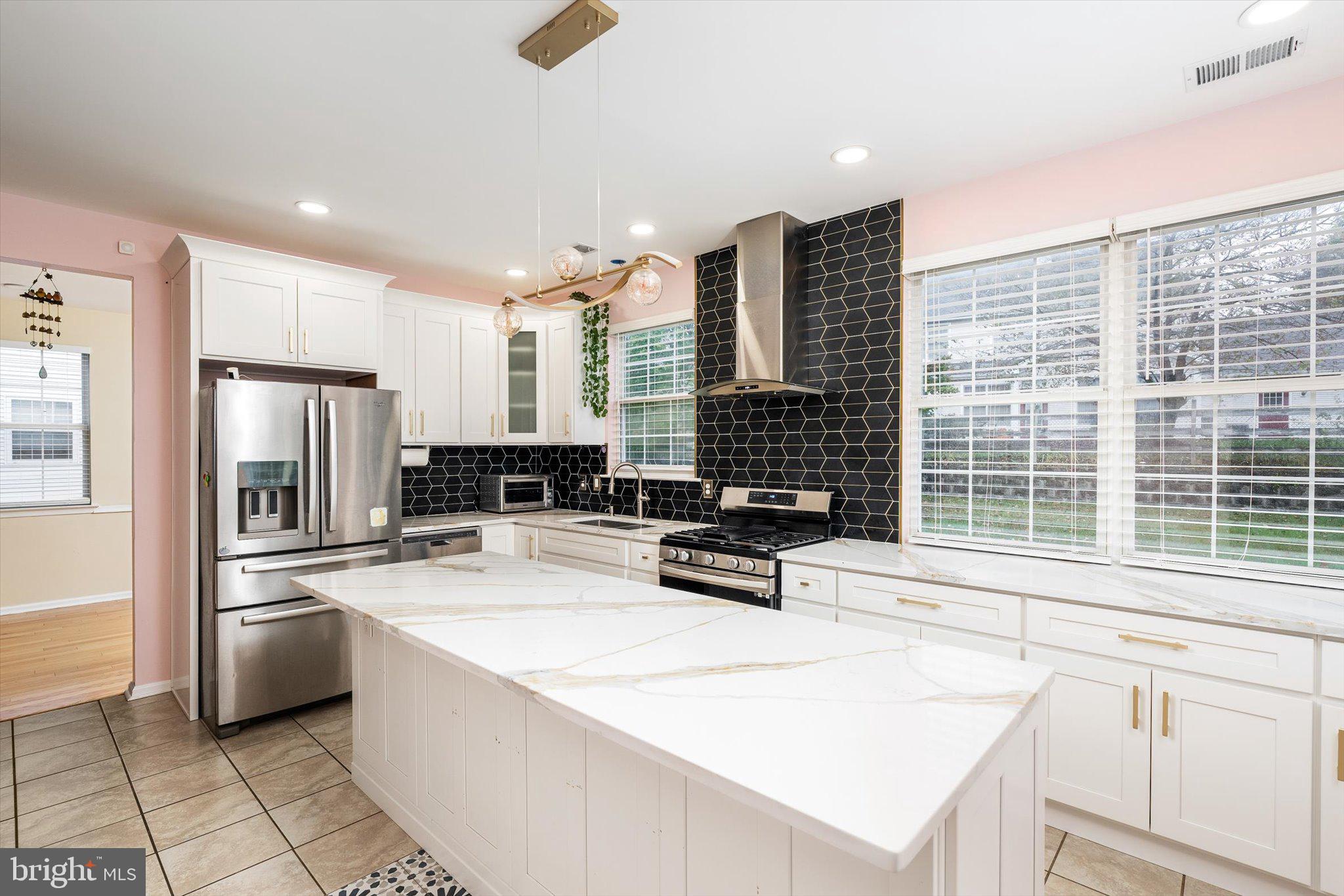 410 Denow Road Pennington, NJ 08534 - Photo 13 of 29 a kitchen with stainless steel appliances kitchen island granite countertop a sink a stove a refrigerator and white cabinets with wooden floor