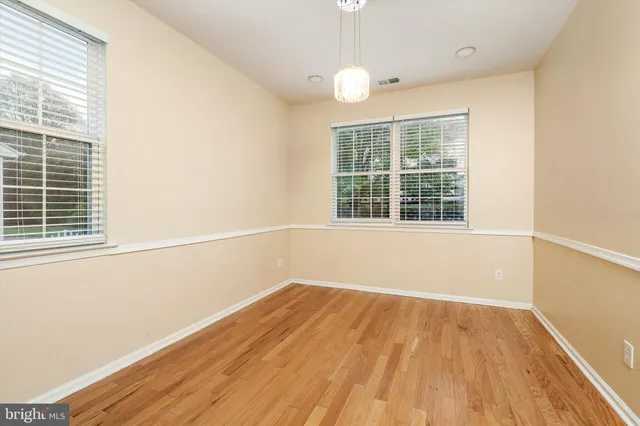 a view of a room with wooden floor and windows