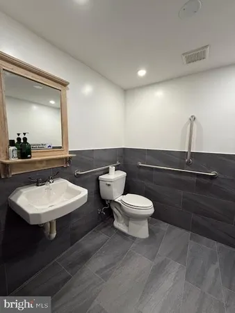 a bathroom with a toilet sink and mirror
