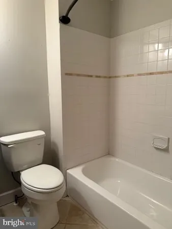 a white toilet sitting next to a bath tub