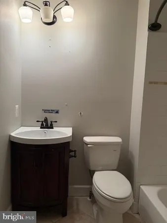 a bathroom with a sink toilet and a mirror