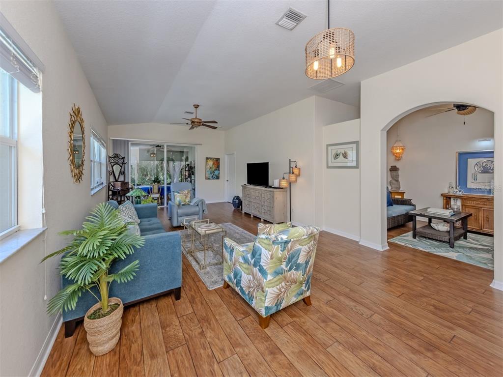 205 Reclinata Circle Venice, FL 34292 - Photo 11 of 62 a living room with furniture chandelier and a flat screen tv