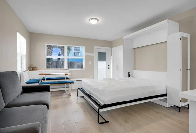 a bedroom with a bed couch and a window