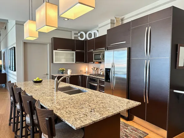 a view of a dining room with furniture a kitchen and chandelier