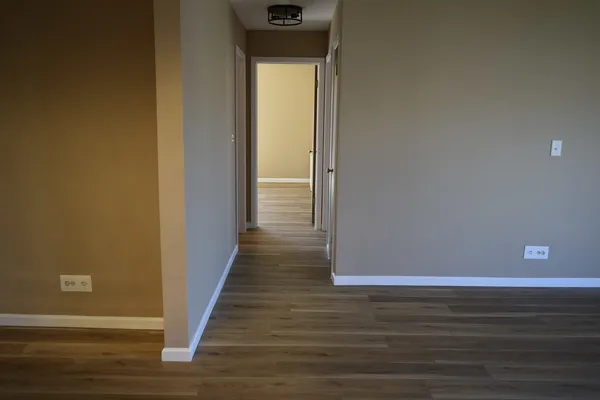 a view of a hallway with wooden floor