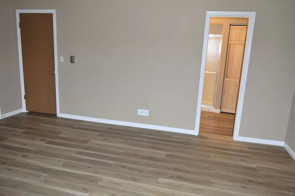 a view of an empty room with wooden floor