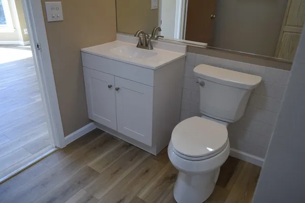 a bathroom with a toilet sink and a mirror