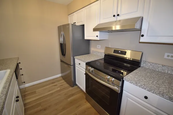 a kitchen with stainless steel appliances granite countertop a refrigerator and a stove