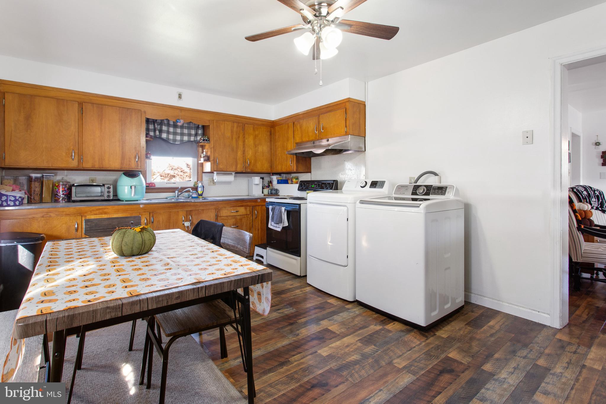 400 Linden Avenue Hanover, PA 17331 - Photo 18 of 43 a kitchen with stainless steel appliances granite countertop a stove a refrigerator a sink a dining table and chairs with wooden floor