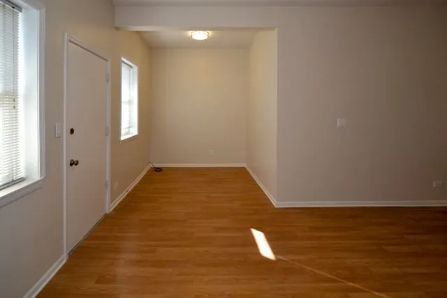 a view of a room with wooden floor and white walls