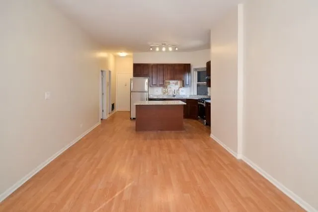 a view of kitchen with sink and refrigerator