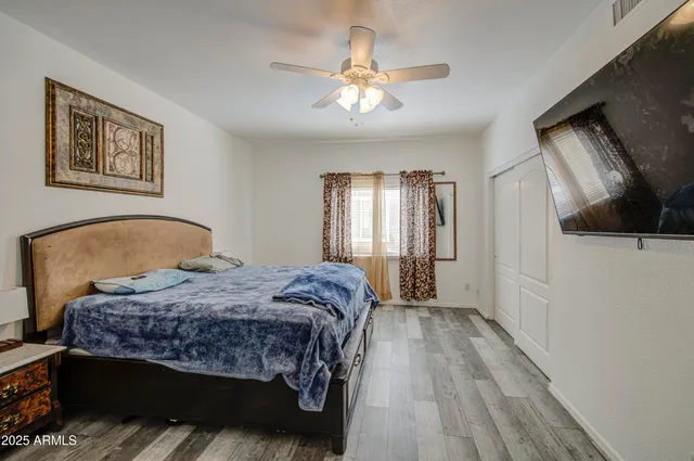 a bedroom with a large bed and a chandelier
