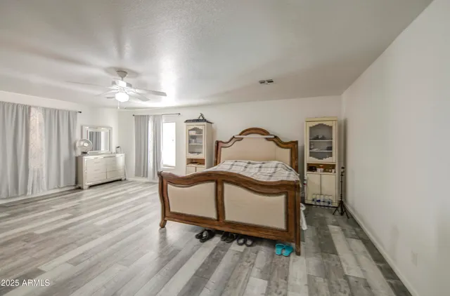 a view of a bedroom with a bed and wooden floor