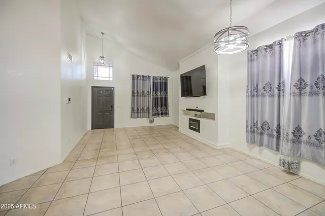 a view of a livingroom with furniture chandelier fan and windows