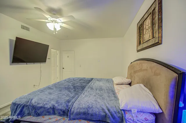 a bedroom with a bed and a flat screen tv