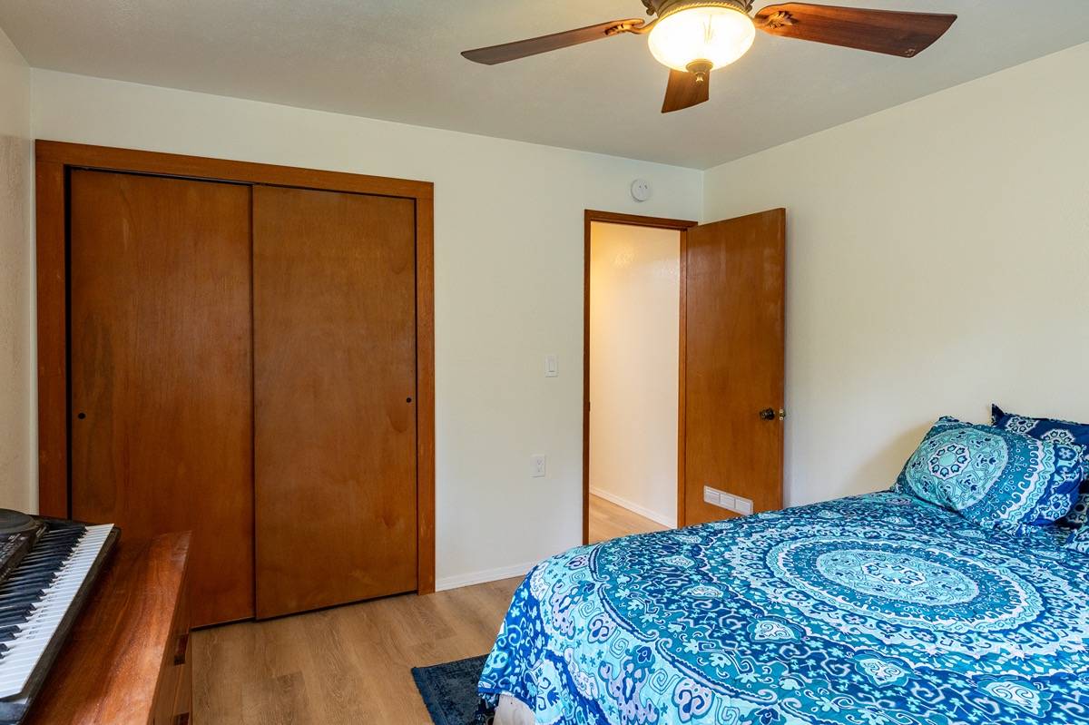 16-1404 Hopue Road Mountain View, HI 96771 - Photo 13 of 28 a bedroom with a bed and wooden floor
