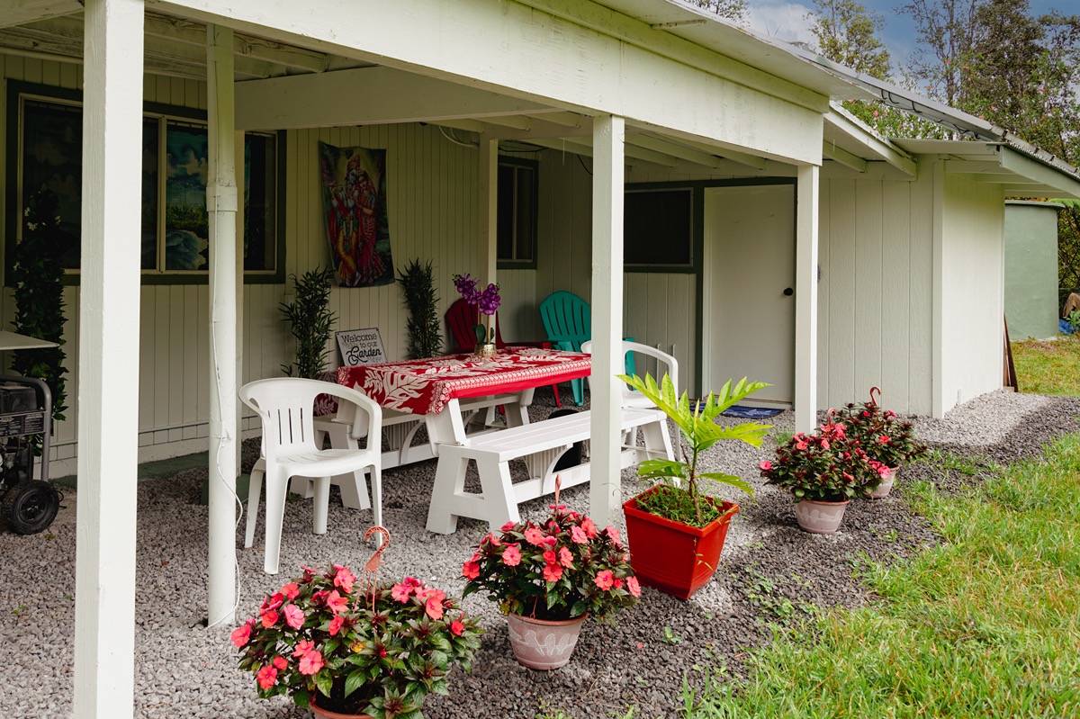 16-1404 Hopue Road Mountain View, HI 96771 - Photo 17 of 28 a group of flowers sitting in front of yellow house