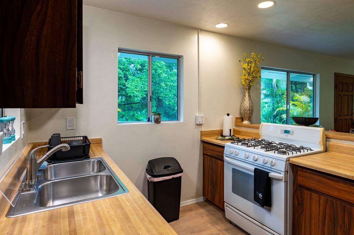 16-1404 Hopue Road Mountain View, HI 96771 - Photo 10 of 28 a kitchen with granite countertop a stove and a sink