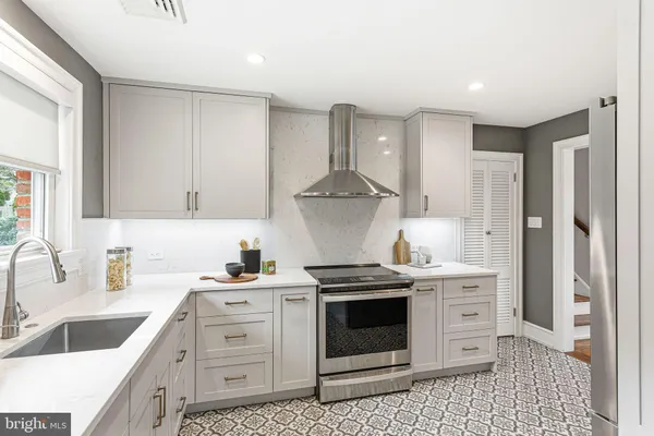 a kitchen with stainless steel appliances a stove a sink and a refrigerator