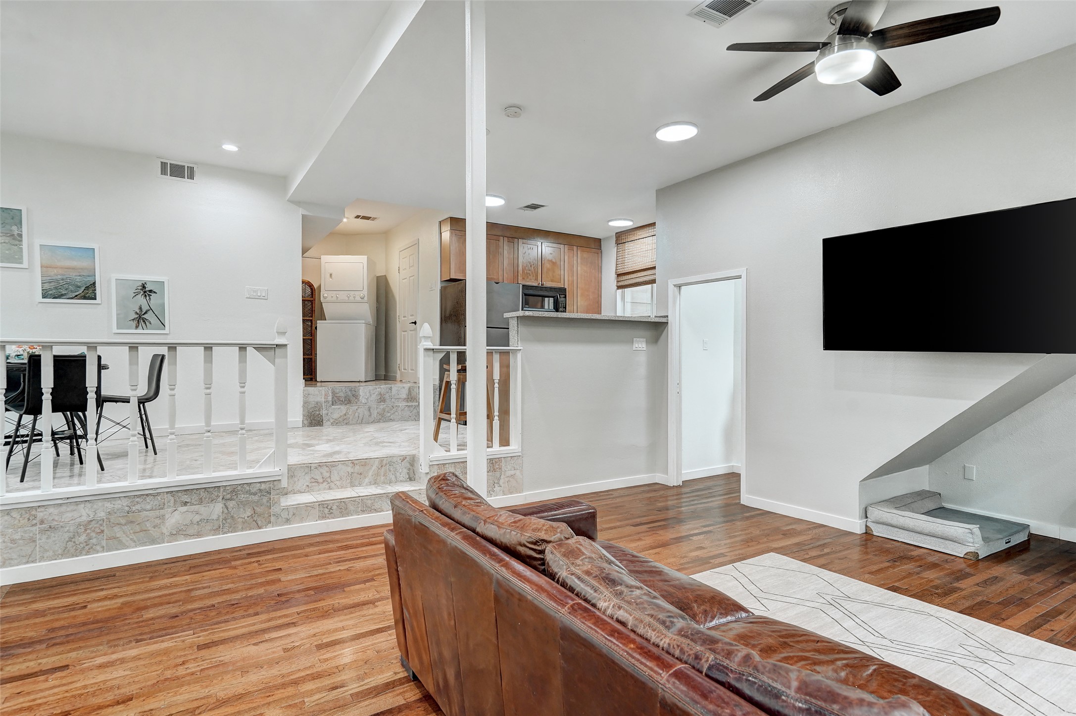 8804 Mountain Ridge Drive, Unit B Austin, TX 78759 - Photo 7 of 17 Rich hardwood floors complement a versatile open-concept living area and kitchen, perfect for entertaining.