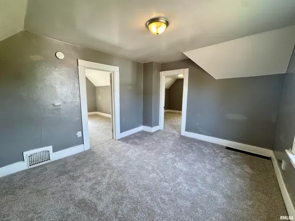 an empty room with windows and closet