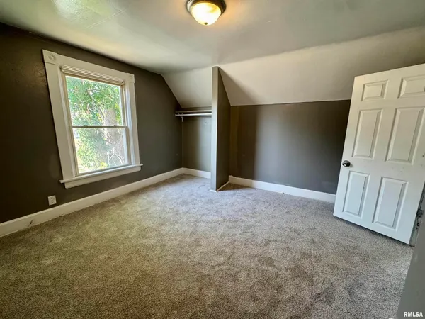 an empty room with windows and closet