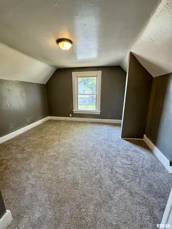 an empty room with a window and a fireplace