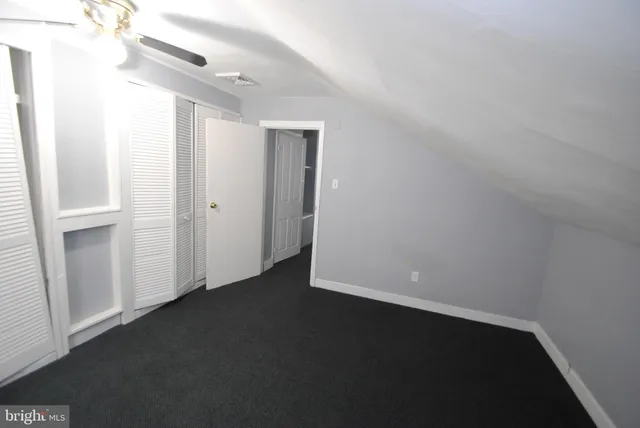 an empty room with a ceiling fan and a window