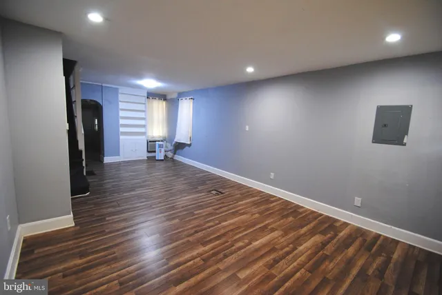an empty room with wooden floor and a window