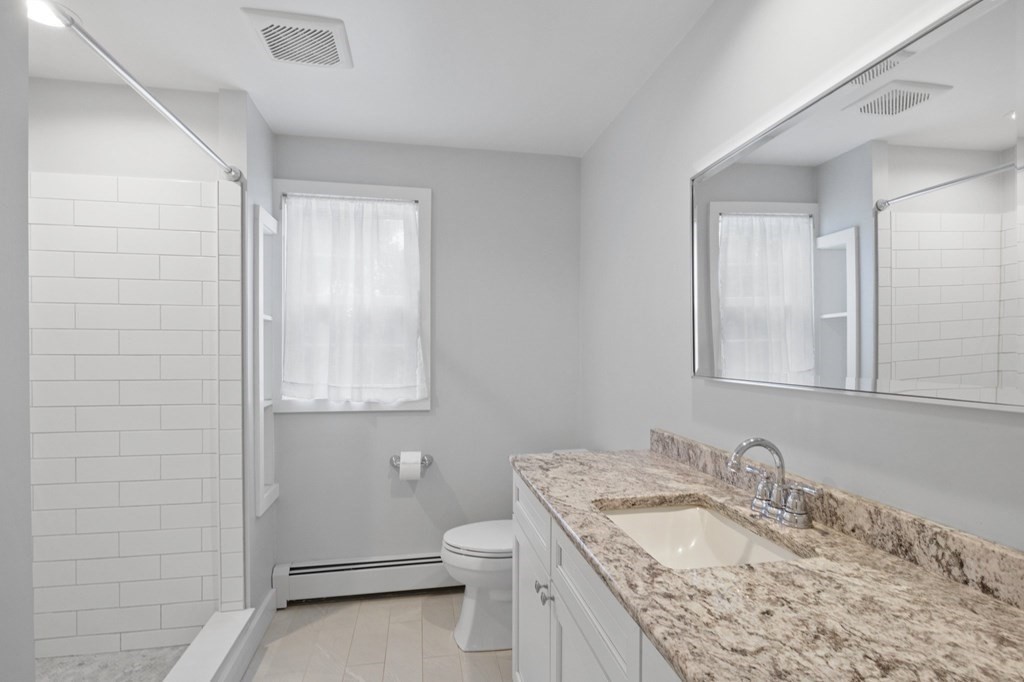 29 Stuart Road Rochester, MA 02770 - Photo 19 of 41 a bathroom with a granite countertop sink a toilet and a mirror