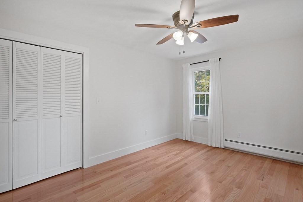 29 Stuart Road Rochester, MA 02770 - Photo 24 of 41 an empty room with wooden floor chandelier fan and windows