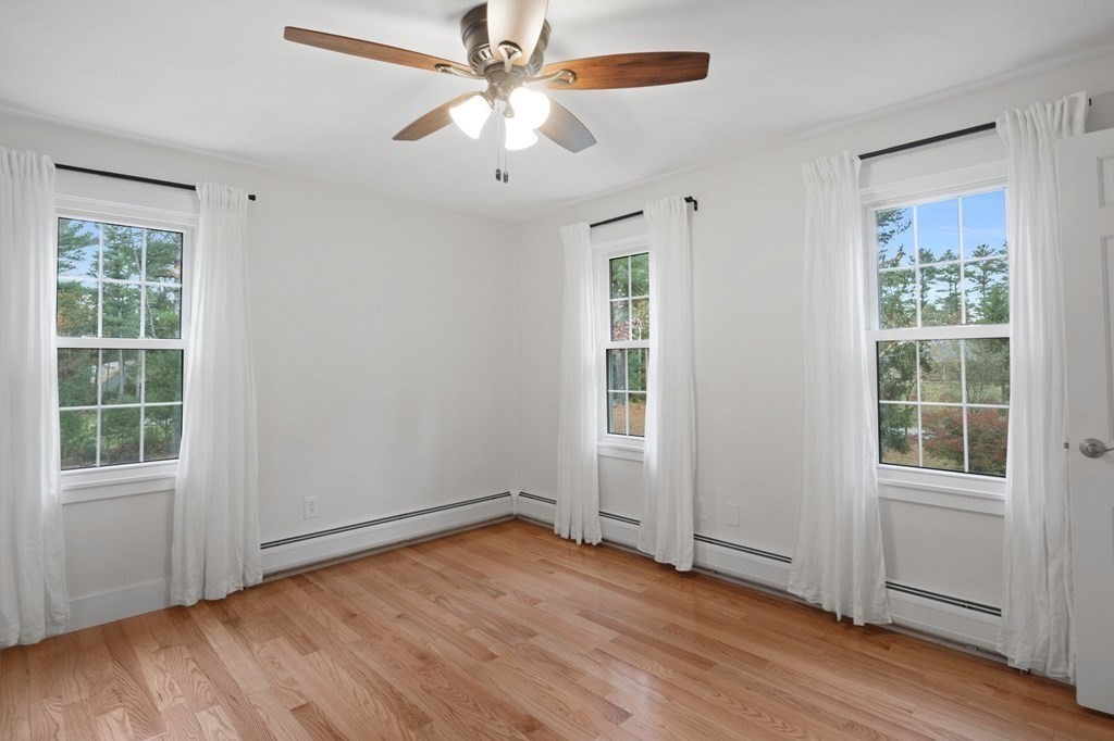 29 Stuart Road Rochester, MA 02770 - Photo 25 of 41 an empty room with wooden floor chandelier fan and windows