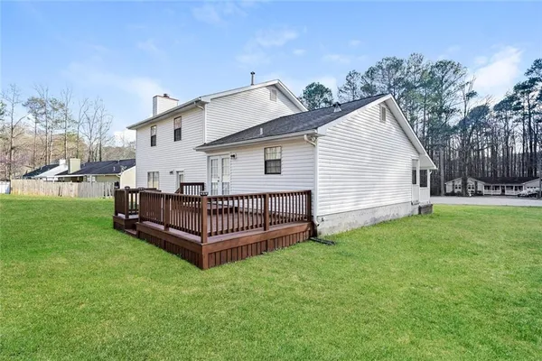 a view of a house with a yard and deck