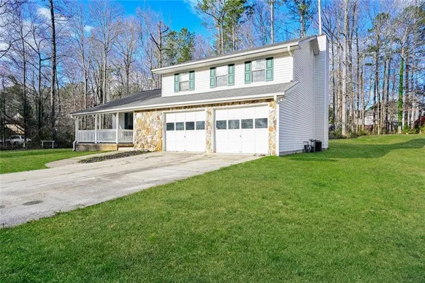 a front view of a house with a yard and trees