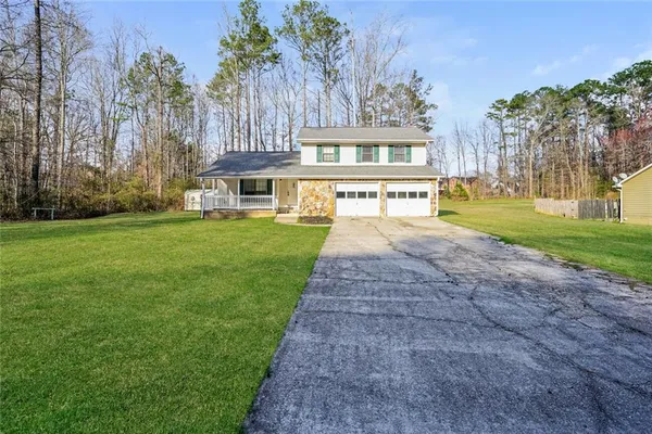 a front view of a house with a yard and trees