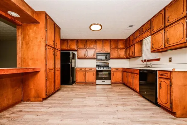 a kitchen with stainless steel appliances kitchen island granite countertop a refrigerator and a stove top oven